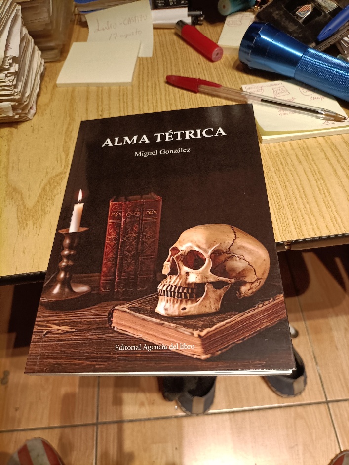 Ejemplar del libro Alma tétrica de Miguel González sobre una mesa junto a papeles